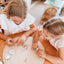 Two girls making the poppy and daisy pastel bag tag kit