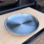 Adult stainless steel double wall camping plate on wooden chopping board in camper van