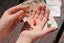 Child's hands pouring ladybugs out of glass jar onto hand 