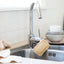 Natural plastic free dish sponge loofah hanging to dry from kitchen tap