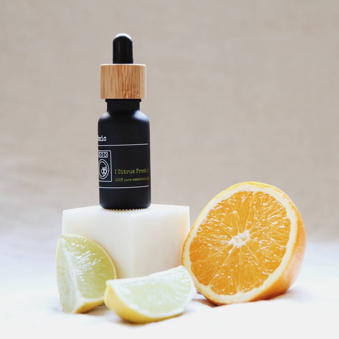 that red house laundry tonic citrus fresh essential oil bottle with lemon and orange fruit slices