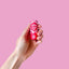 A hand holding a Viva La Body Patchouli Rose solid perfume tube 