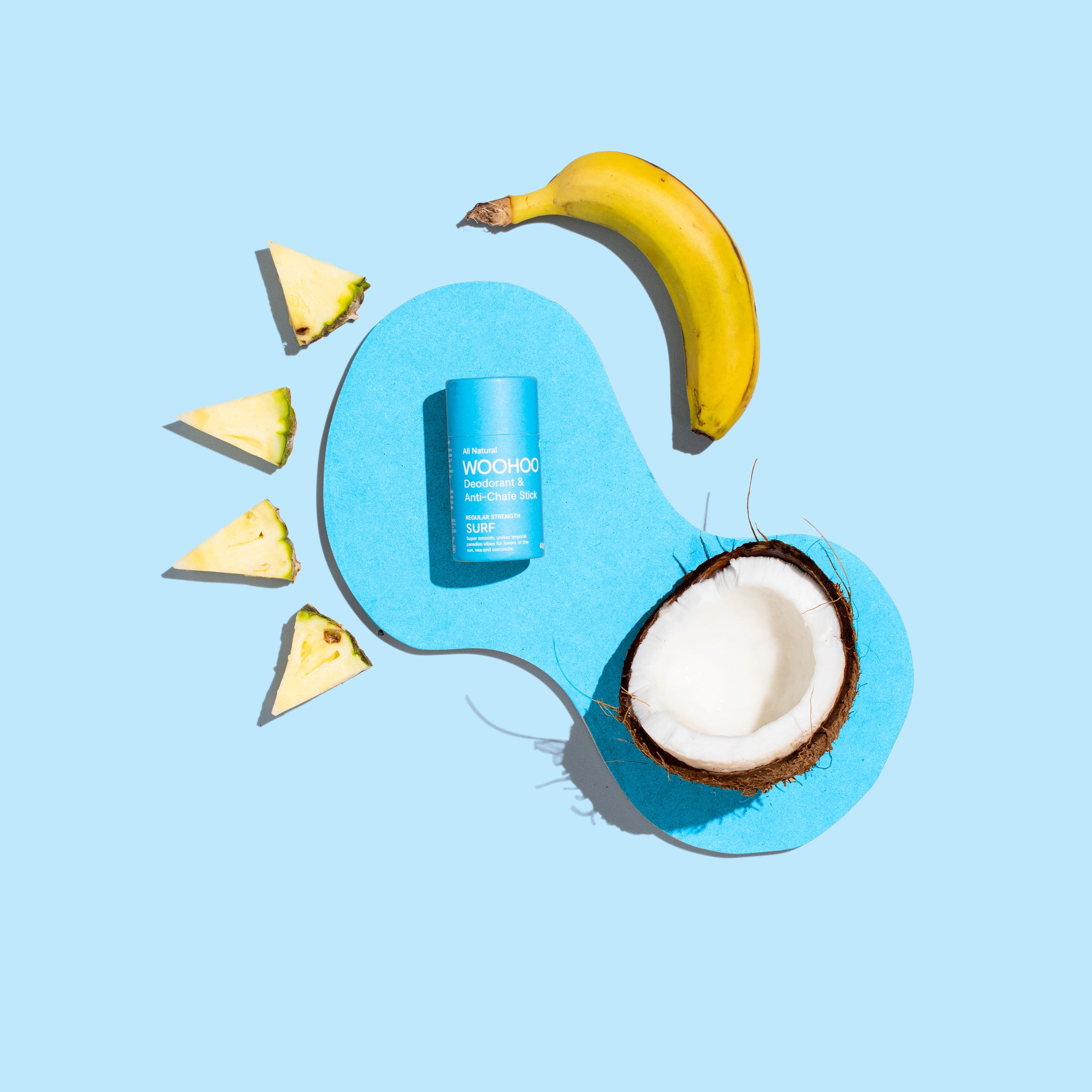 woohoo surf all natural deodorant and anti-chafe stick 60 grams front of packaging tube with banana pineapple slices and half a coconut